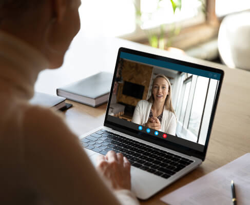 a person engaged in a video call via a laptop, interacting with a client in a demo session